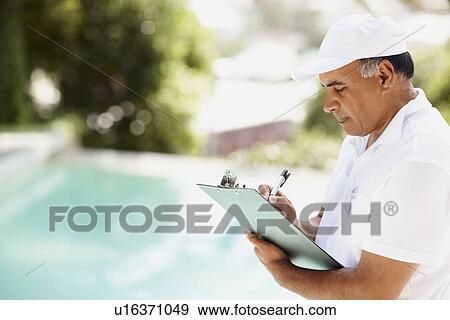 Tradesman writing on clipboard View Large Photo Image Stock Photo - Tradesman writing on clipboard. Fotosearch