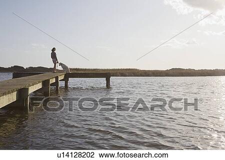 Woman and dog on pier View Large Photo Image Stock Image - Woman and dog on pier. Fotosearch