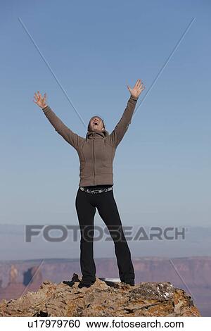 Stock Image - Woman at top of canyon. Fotosearch