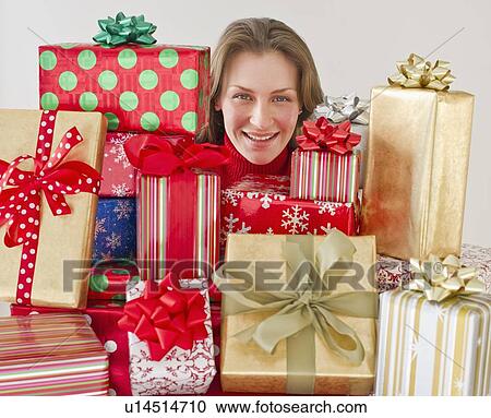 Stock Image - Woman behind Christmas presents. Fotosearch