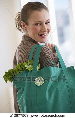 Stock Photo - Woman carrying bag of groceries. Fotosearch