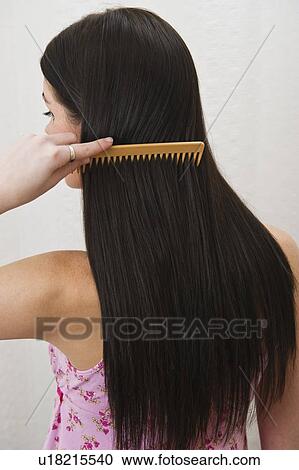 Stock Image - Woman combing her hair. Fotosearch