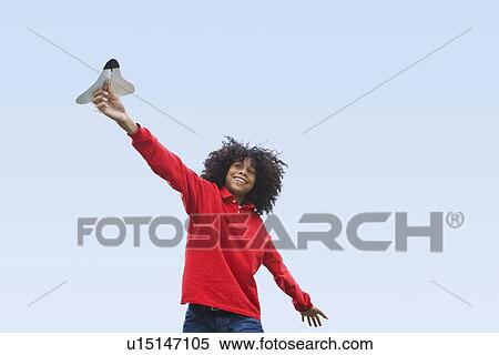 Stock Photography - Woman flying toy plane. Fotosearch