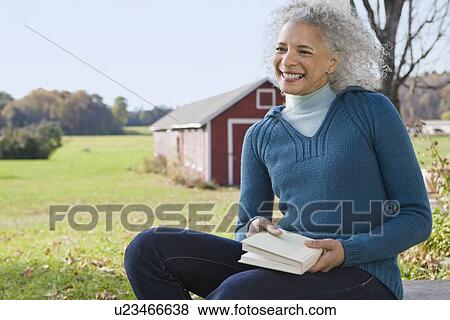 Woman holding a book View Large Photo Image Stock Photo - Woman holding a book. Fotosearch