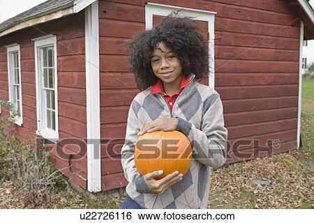 Woman holding a pumpkin View Large Photo Image Stock Photograph - Woman holding a pumpkin. Fotosearch