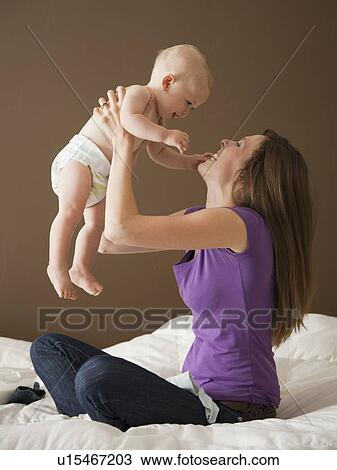 Stock Image - Woman holding baby. Fotosearch