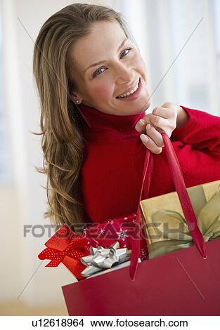 Picture - Woman holding bag of gifts. Fotosearch