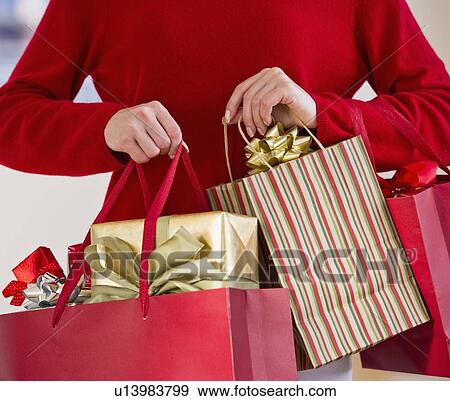 Woman holding bags of gifts View Large Photo Image Stock Photo - Woman holding bags of gifts. Fotosearch