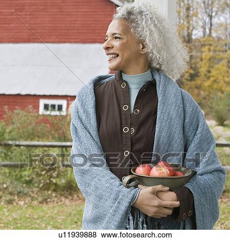 Stock Photo - Woman holding bowl of apples. Fotosearch