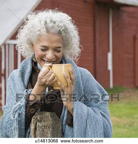 Stock Photo - Woman holding mug outside. Fotosearch