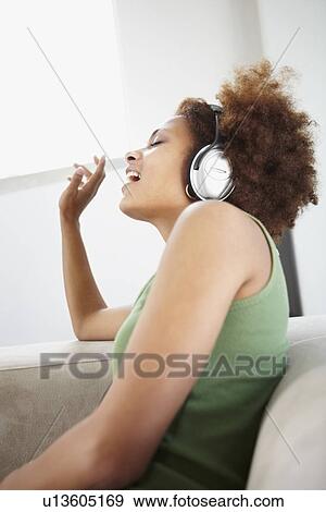 Stock Photo - Woman listening to music on headphones. Fotosearch