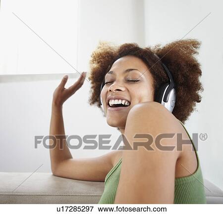 Woman listening to music on headphones View Large Photo Image Stock Photo - Woman listening to music on headphones. Fotosearch