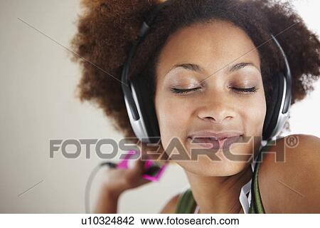 Stock Image - Woman listening to music. Fotosearch