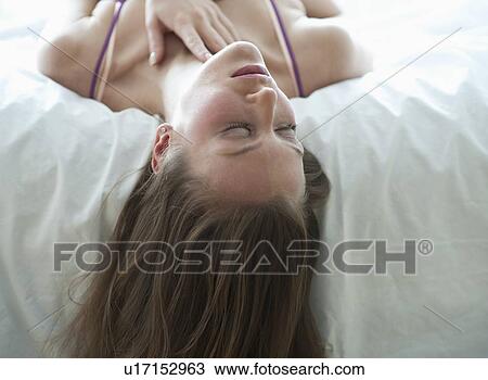 Woman lying on bed View Large Photo Image Stock Image - Woman lying on bed. Fotosearch