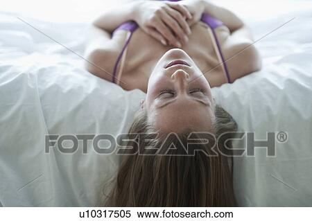 Stock Photography - Woman lying on bed. Fotosearch
