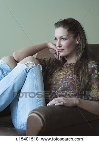 Stock Photo - Woman sitting in chair. Fotosearch