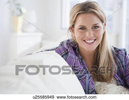 Stock Photo - Woman sitting on couch. Fotosearch