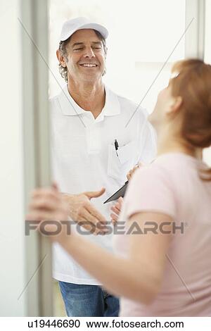 Woman talking to man at the door View Large Photo Image Stock Image - Woman talking to man at the door. Fotosearch