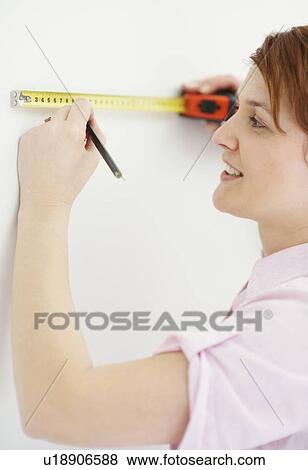 Stock Photo - Woman using measuring tape. Fotosearch