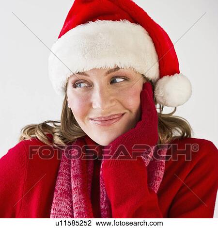Stock Image - Woman wearing Santa hat. Fotosearch