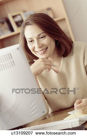 Stock Photo - Woman working at computer. Fotosearch