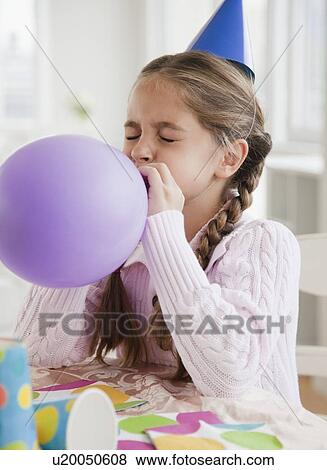 Young girl blowing up balloon View Large Photo Image Stock Photo - Young girl blowing up balloon. Fotosearch