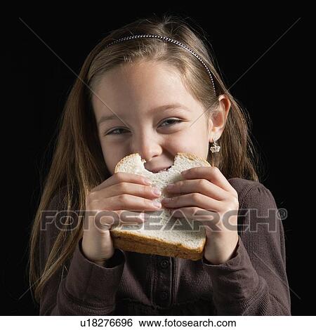 Stock Photograph - Young girl eating a sandwich. Fotosearch