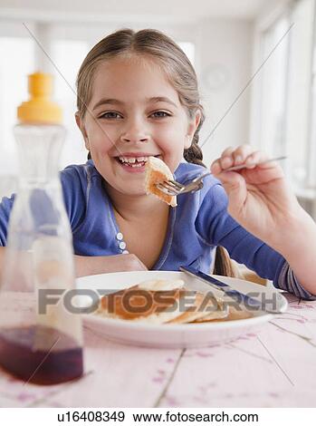 Young girl eating pancakes View Large Photo Image Stock Photo - Young girl eating pancakes. Fotosearch