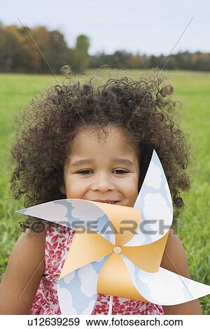 Stock Photo - Young girl holding toy windmill. Fotosearch