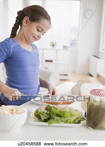Stock Photo - Young girl making sandwich. Fotosearch