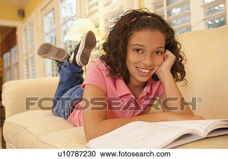 Stock Image - Young girl on couch. Fotosearch