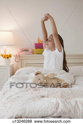 Young girl stretching in bed View Large Photo Image Stock Photo - Young girl stretching in bed. Fotosearch