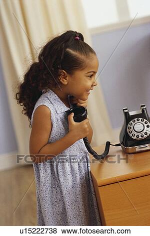 Stock Photo - Young girl talking on telephone. Fotosearch