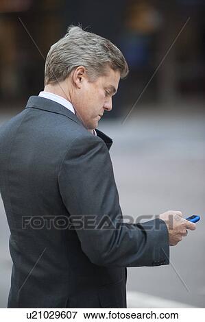 Stock Photo - Chicago Man in Business Suit checking his cell phone. Fotosearch