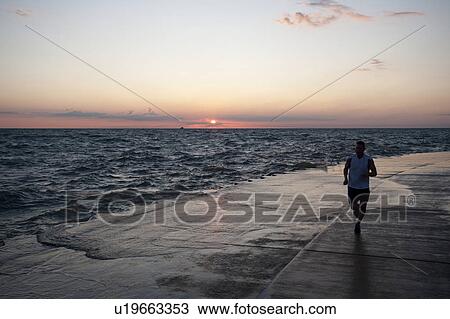 Stock Image - Man jogging in Chicago, Lake Michigan. Fotosearch
