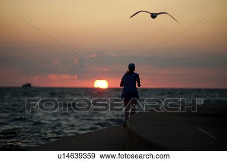 Stock Photo - Woman jogging in Chicago, along Lake Michigan. Fotosearch