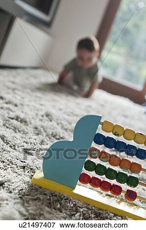 Stock Photo - Baby boy crawling toward abacus. Fotosearch