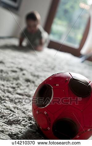 Stock Image - Baby boy crawling toward ball. Fotosearch