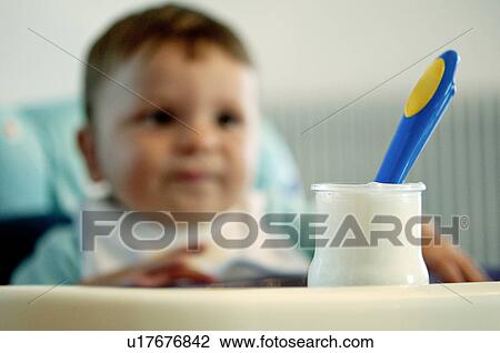 Baby boy in high chair with jar of yogurt and spoon View Large Photo Image Stock Image - Baby boy in high chair with jar of yogurt and spoon. Fotosearch