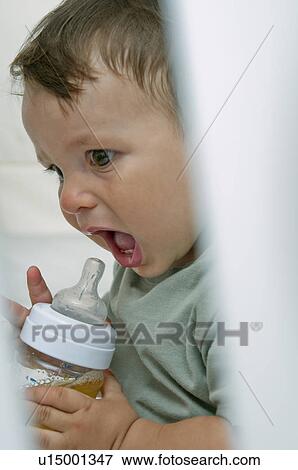Baby boy with bottle and mouth open View Large Photo Image Stock Photo - Baby boy with bottle and mouth open. Fotosearch