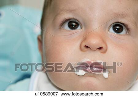 Stock Photo - Closeup of baby boy's face with food around his mouth. Fotosearch