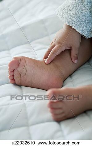 Stock Image - Closeup of baby's feet and hand. Fotosearch