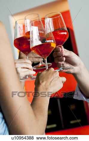 Stock Photo - Closeup of hands holding wine glasses and toasting. Fotosearch
