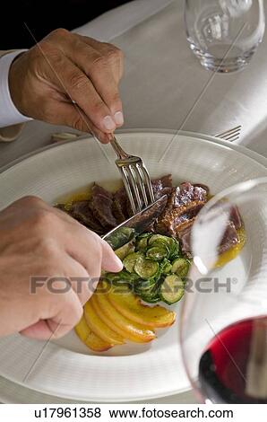 Closeup of young man's hands with knife and fork at his plate View Large Photo Image Stock Photo - Closeup of young man's hands with knife and fork at his plate. Fotosearch