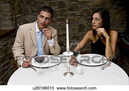 Stock Photography - Couple sitting at restaurant table. Fotosearch