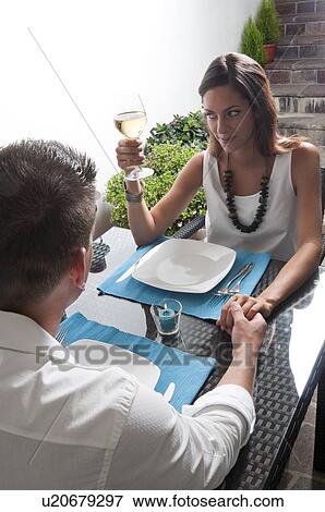 Stock Photo - Couple sitting at table drinking white wine. Fotosearch