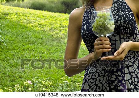 Torso of young woman in vineyard with a wineglass of white grapes View Large Photo Image Stock Photo - Torso of young woman in vineyard with a wineglass of white grapes. Fotosearch
