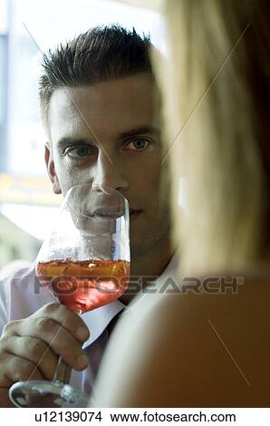 Young man sitting with a glass of orange wine View Large Photo Image Picture - Young man sitting with a glass of orange wine. Fotosearch