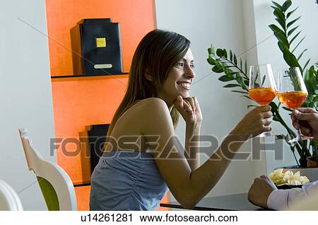 Young woman and young man's hand toasting glasses of orange wine View Large Photo Image Stock Image - Young woman and young man's hand toasting glasses of orange wine. Fotosearch