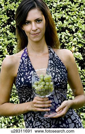 Young woman in vineyard with a wineglass of white grapes View Large Photo Image Stock Image - Young woman in vineyard with a wineglass of white grapes. Fotosearch